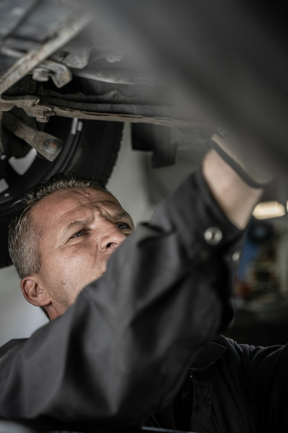 Mechanic working underneath a vehicle on a lift
